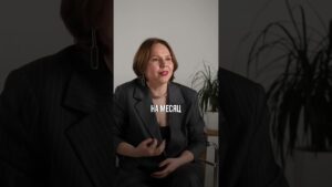 Девушка в костюме сидит на стуле